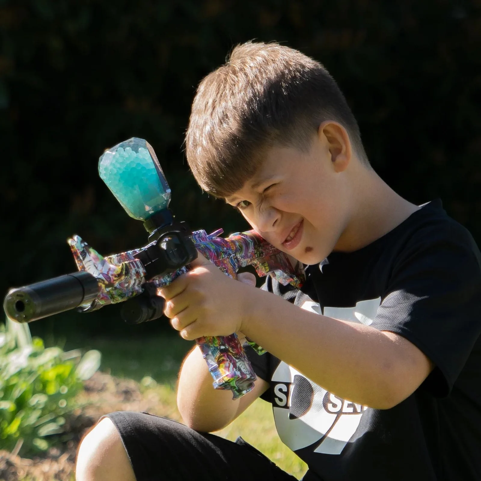 Young person aiming a gel blaster outdoors
