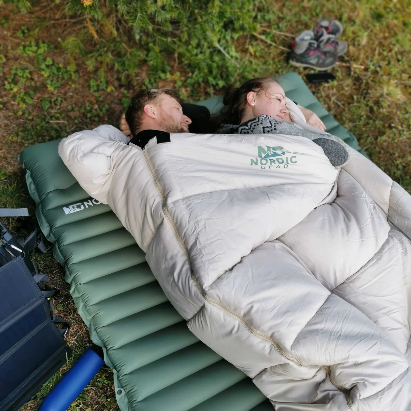 Two campers sharing Nordic Gear bedding outdoors